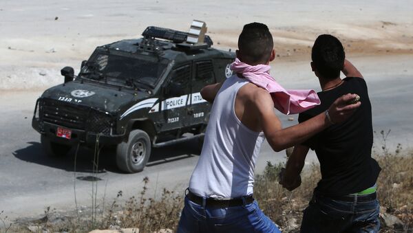 Jovens palestinos lançam pedras contra veículo policial israelense - Sputnik Brasil