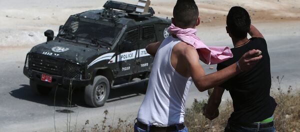 Jovens palestinos lançam pedras contra veículo policial israelense - Sputnik Brasil