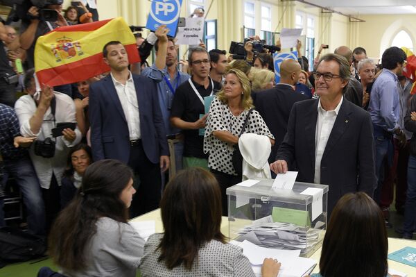Artur Mas votou nas eleições de 27 de setembro. Quando chegou ao local de votação, os adversários da causa independentista levantaram bandeiras espanholas e cartazes com o logo do Partido Popular (PP) - Sputnik Brasil