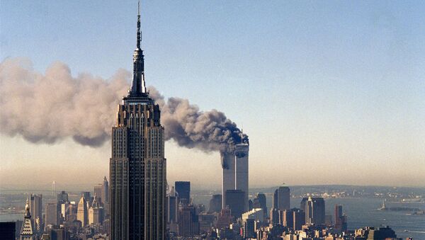 In this Sept. 11, 2001, file photo, the twin towers of the World Trade Center burn behind the Empire State Building in New York. - Sputnik Brasil