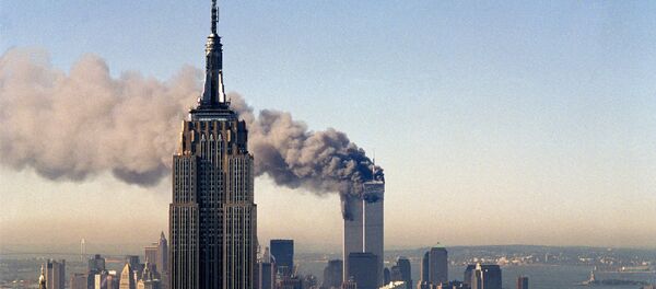 In this Sept. 11, 2001, file photo, the twin towers of the World Trade Center burn behind the Empire State Building in New York. - Sputnik Brasil