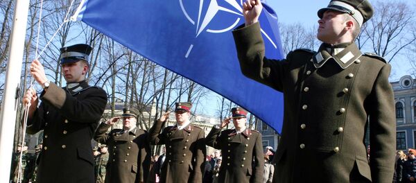Funcionários da Letônia durante cerimônia de hasteamento da bandeira da OTAN em frente ao Castelo da Presidência em Riga - Sputnik Brasil