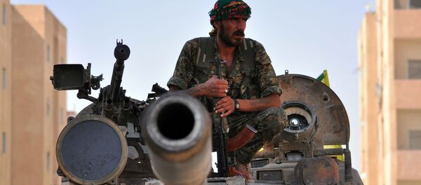 Combatente curdo senta em tanque do Exército sírio. - Sputnik Brasil