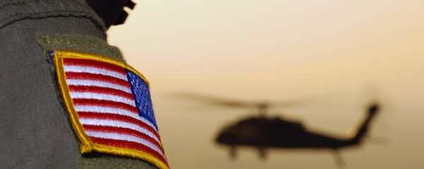 Bandeira americana de oficial do exército americano com um helicóptero UH-60A Black Hawk ao fundo - Sputnik Brasil