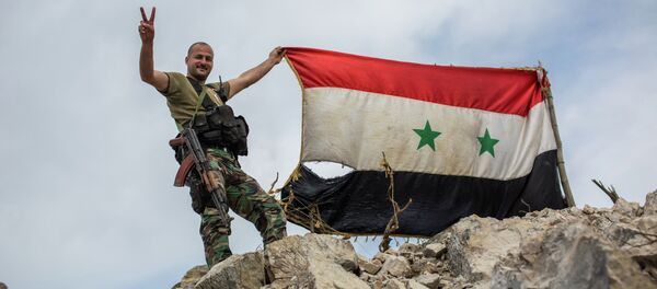A government soldier with the Syrian flag on a location on top of a hill not far from Kessab on the Turkish border following an Islamist takeover of the town - Sputnik Brasil