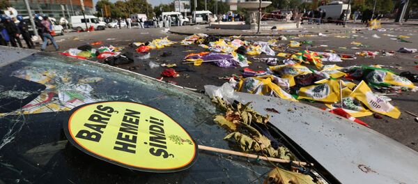 A placard that reads in Turkish: 'Peace Immediately Now' , is seen at the site of an explosion with the bodies of victims covered with flags and banners in the background, in Ankara, Turkey - Sputnik Brasil