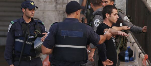 Policiais israelenses estão revistando um jovem palestiniano próximo à entrada à Cidade Antiga em Jerusalém Oriental, 13 de outubro de 2015 - Sputnik Brasil