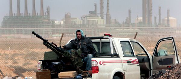 Rebelde em frente à refinaria de petróleo, após captura pelas forças opositoras ao governo da cidade de Ras Lanouf, no Leste da Líbia Rebelde em frente à refinaria de petróleo, após captura pelas forças opositoras ao governo da cidade de Ras Lanouf, no Leste da Líbia - Sputnik Brasil