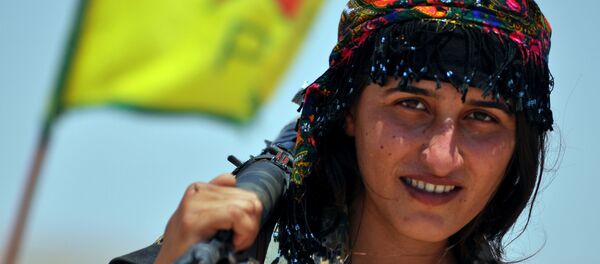 Uma miliciana da Unidade de Proteção do Povo (YPG) curda posa para uma foto com sua arma, na cidade síria de Ain Issi, cerca de 50 quilômetros norte de Raqqa, o chamado capital do Estado Islâmico. - Sputnik Brasil