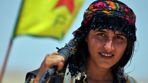 Uma miliciana da Unidade de Proteção do Povo (YPG) curda posa para uma foto com sua arma, na cidade síria de Ain Issi, cerca de 50 quilômetros norte de Raqqa, o chamado capital do Estado Islâmico. - Sputnik Brasil