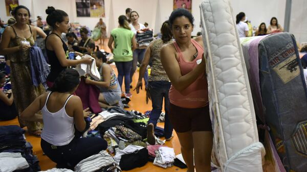 Pessoas trazem suprimentos para o ginásio Arena Mariana, onde ficarão abrigadas as vítimas da inundação, provocada pelo rompimento da barragem - Sputnik Brasil