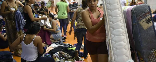 Pessoas trazem suprimentos para o ginásio Arena Mariana, onde ficarão abrigadas as vítimas da inundação, provocada pelo rompimento da barragem - Sputnik Brasil