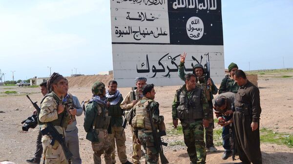 Combatentes peshmerga do Curdistão iraquiano ao lado de uma placa do Daesh - Sputnik Brasil