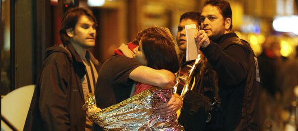 As pessoas se abraçam antes de serem evacuadas de autocarro, perto da sala dos concertos Bataclan, Paris, 14 de novembro, 2015 As pessoas se abraçam antes de serem evacuadas de autocarro, perto da sala dos concertos Bataclan, Paris, 14 de novembro, 2015 - Sputnik Brasil