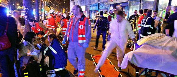 Pessoas descansam após evacuação da casa de shows Bataclan em Paris, 13 de novembro de 2015 - Sputnik Brasil
