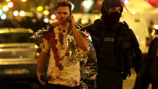 Um jovem sai da sala de concertos Bataclan após atentado em Paris, na noite de 13 para 14 de novembro - Sputnik Brasil
