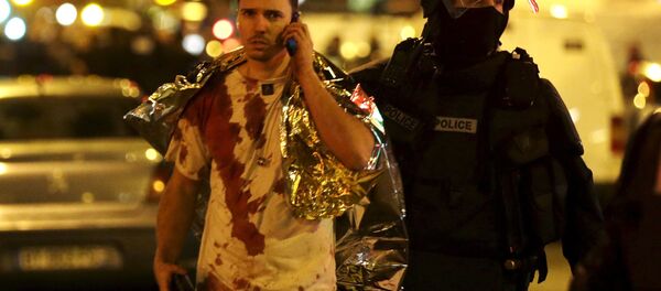 Um jovem sai da sala de concertos Bataclan após atentado em Paris, na noite de 13 para 14 de novembro - Sputnik Brasil