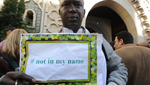 Foto de arquivo de um homem com o cartaz Não em meu nome, durante uma manifestação convocada por grupos muçulmanos a denunciar a barbárie dos militantes do Estado Islâmico, em 26 de setembro de 2014 fora a principal mesquita de Paris - Sputnik Brasil
