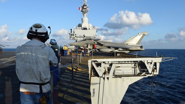 French navy technicians work near a French Rafale aircraft on the flight deck on the aircraft carrier Charles-de-Gaulle, in eastern Mediterranean sea, on November 21, 2015 - Sputnik Brasil