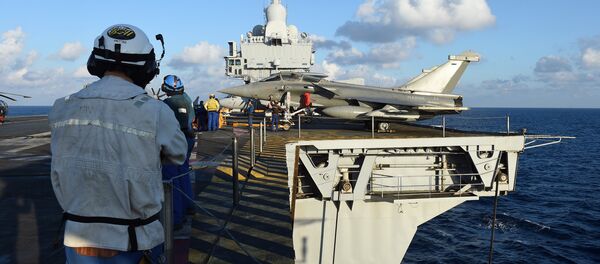 French navy technicians work near a French Rafale aircraft on the flight deck on the aircraft carrier Charles-de-Gaulle, in eastern Mediterranean sea, on November 21, 2015 French navy technicians work near a French Rafale aircraft on the flight deck on the aircraft carrier Charles-de-Gaulle, in eastern Mediterranean sea, on November 21, 2015 - Sputnik Brasil