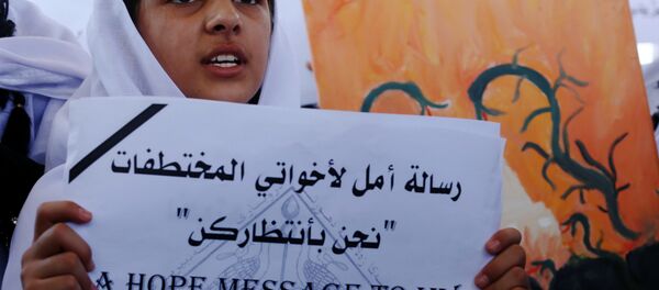 Menina yazidi empunha um cartaz que diz Mensagem de esperança para a minha irmã: estamos à tua espera durante o protesto perto do escritório da ONU em Arbil, capital da região autónoma de Curdistão, Iraque, 2 de agosto de 2015 - Sputnik Brasil