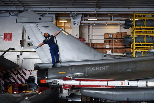 Um técnico francês faz a manutenção de um caça Rafale a bordo do porta-aviões Charles de Gaulle - Sputnik Brasil