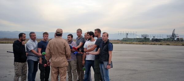 Piloto salvo do Su-24, Konstantin Murakhtin, (ao centro de costas) fala com jornalistas na base áerea de Hmeymim, Lataquia, Síria, 25 de novembro de 2015 - Sputnik Brasil