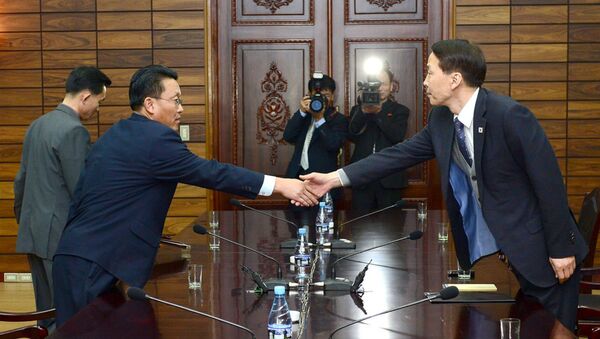 O chefe da delegação sul-coreana, Kim Ki-Woong (dir.) aperta a mão com do seu homólogo norte-coreano, Hwang Chol. - Sputnik Brasil