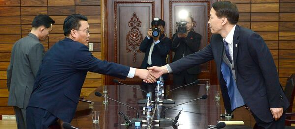 O chefe da delegação sul-coreana, Kim Ki-Woong (dir.) aperta a mão com do seu homólogo norte-coreano, Hwang Chol. - Sputnik Brasil