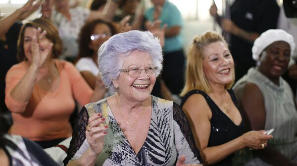 Uma mulher aplaude o seu namorado idoso que participa no concurso Homem mais bonito idoso em São Paulo. 6 de agosto, 2015 - Sputnik Brasil