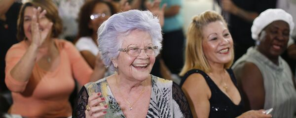 Uma mulher aplaude o seu namorado idoso que participa no concurso Homem mais bonito idoso em São Paulo. 6 de agosto, 2015 - Sputnik Brasil