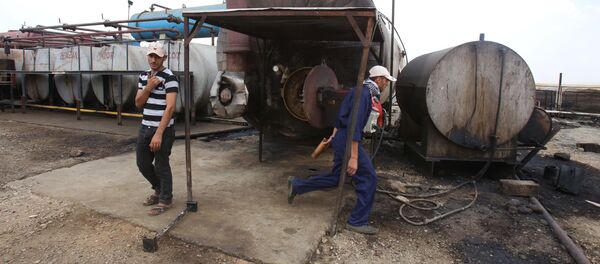 Men work on cauldron in the Rmeilane oil field in Syria's northern eastern Hasakeh province on July 15, 2015 - Sputnik Brasil