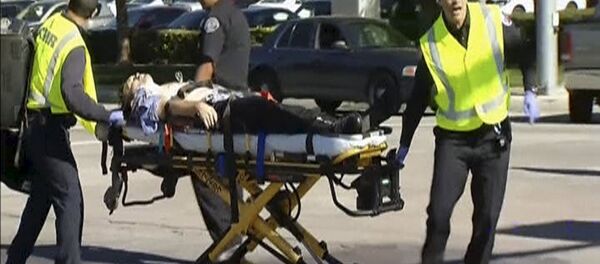 Still from video shows rescue crews tending to the injured in the intersection outside the Inland Regional Center in San Bernardino - Sputnik Brasil