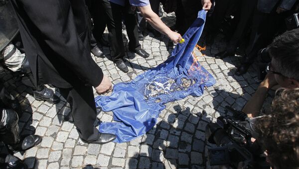 Manifestantes queimam a bandeira da OTAN durante protesto em Belgrado, Sérvia (imagem do arquivo) - Sputnik Brasil