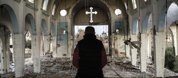 Morador de uma aldeia cristã da província de Al-Hasaka, no nordeste da Síria, reza na igreja de São Jorge, destruída pelos terroristas do Daesh - Sputnik Brasil