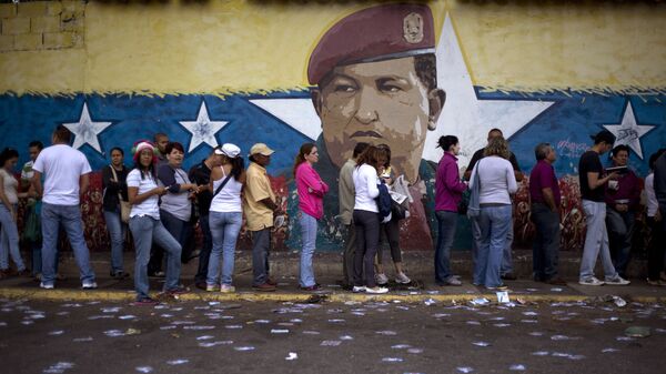 Venezuelanos fazem fila para participar das eleições em seu país em frente a muro com a imagem do ex-presidente Hugo Chávez - Sputnik Brasil