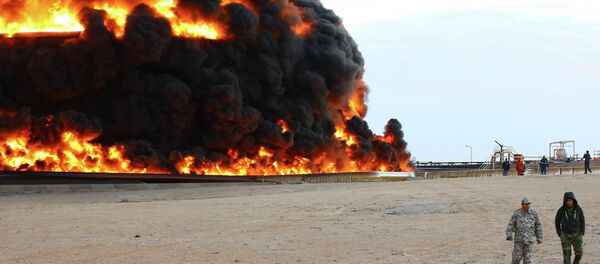 Bombeiros tentam apagar um incêndio em um tanque de petróleo no porto de Es Sider, na Líbia, em 26 de dezembro de 2014 Bombeiros tentam apagar um incêndio em um tanque de petróleo no porto de Es Sider, na Líbia, em 26 de dezembro de 2014 - Sputnik Brasil