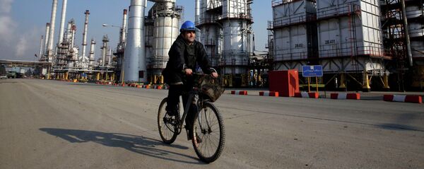 Funcionário do setor petrolífero iraniano vai de bicicleta  perto da refinaria petrolífera no sul de Teerã, Irã - Sputnik Brasil
