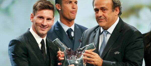 Barcelona's Lionel Messi (L) receives from UEFA President Michel Platini the Best Player UEFA 2015 Award during the draw ceremony for the 2015/2016 Champions League Cup soccer competition at Monaco's Grimaldi Forum while Cristiano Ronaldo (C) looks on in Monte Carlo August 27, 2015 - Sputnik Brasil
