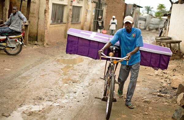 Uma pessoa transporta em sua bicicleta um caixão em Kanyosha, subúrbio de Bujumbura, em 10 de abril de 2015 Uma pessoa transporta em sua bicicleta um caixão em Kanyosha, subúrbio de Bujumbura, em 10 de abril de 2015 - Sputnik Brasil