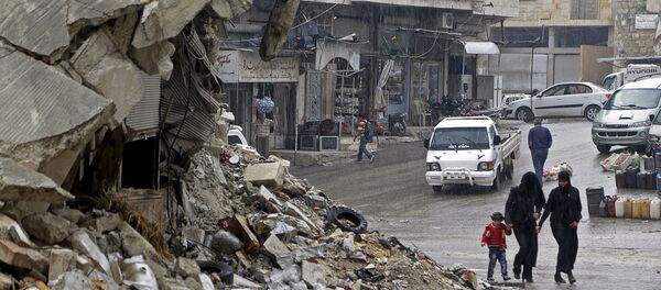 Civilians walk in the rain past a damaged building in the rebel-controlled area of Maaret al-Numan town in Idlib province, Syria October 28, 2015 - Sputnik Brasil