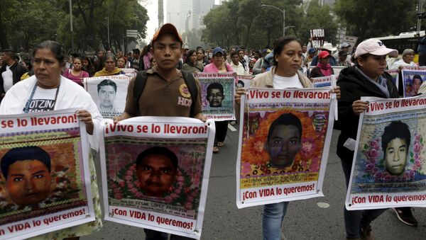 Familiares seguram imagens de alguns dos 43 estudantes desaparecidos de Ayotzinapa, em marcha na Cidade do México - Sputnik Brasil