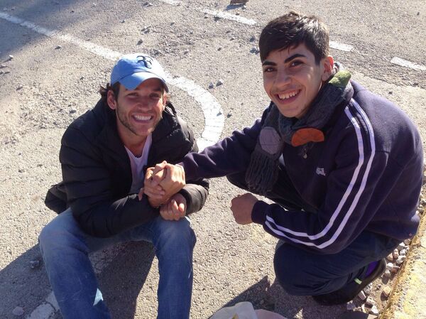 Edgard Raoul com um jovem refugiado sírio. - Sputnik Brasil