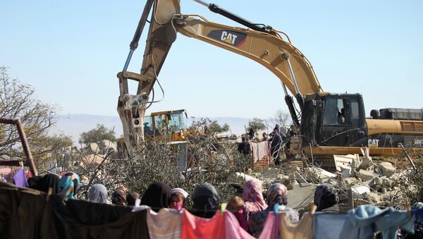 Palestinian women watch on as an Israeli army bulldozer with a demolition permit pulls down the house of the Palestinian Raba'ai family which Israeli authorities said was build without a permit, in Al-Dirat south of Yatta village near the West Bank town of Hebron on January 20, 2015. - Sputnik Brasil