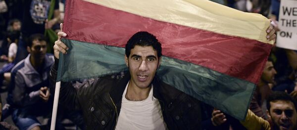 Homem segura a bandeira do Partido de União Democrática (PYD) dos curdos sírios - Sputnik Brasil