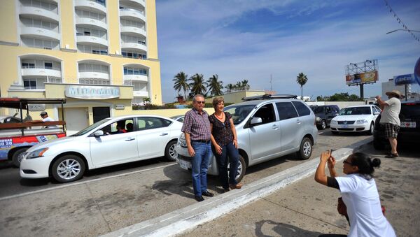 A couple poses for a photo in front of the Miramar condominium in Mazatlan, State of Sinaloa, Mexico - Sputnik Brasil