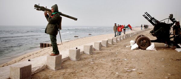 Um militante das forças de autodefesa da Líbia olha o mar Mediterrâneo desde o litoral de Benghazi (2011, foto de arquivo) - Sputnik Brasil