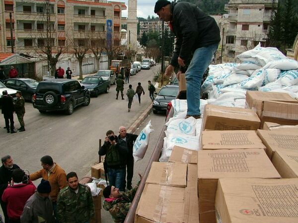Militares descargam ajuda humanitária do caminhão em uma rua da cidade de Kessab, na província síria de Latakia - Sputnik Brasil