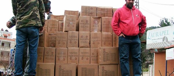 Militares sírios descarregam o caminhão que levou ajuda humanitária russa à cidade de Kessab, na província síria de Latakia, em 12 de feveriro de 2016 - Sputnik Brasil