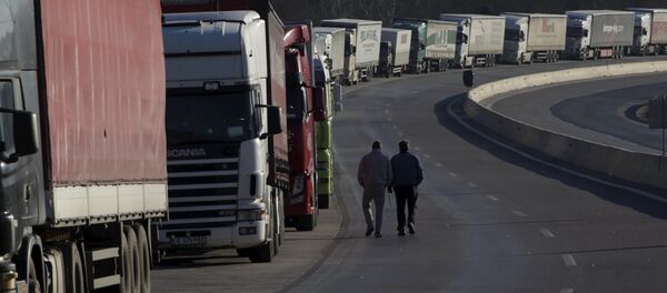 Truck drivers walk next to parked trucks as protesting farmers (not pictured) block the road leading to the border station of Greece with Bulgaria during a demonstration against planned pension reforms near the Greek village of Promachonas. - Sputnik Brasil